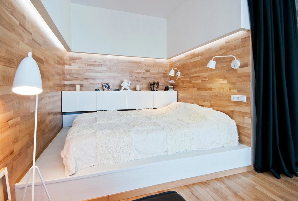 Маленькая комната с кроватью на подиуме из бетона