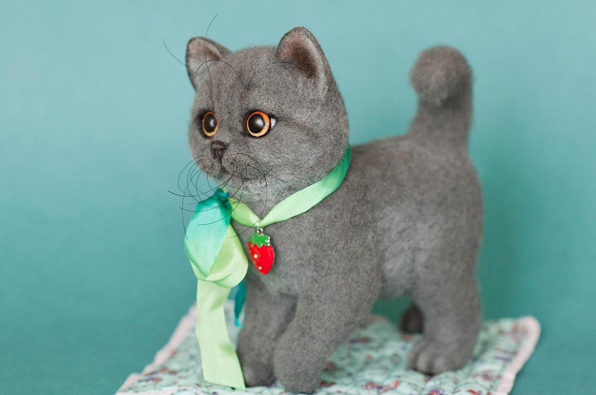 Украсить котенка, сделанного в технике валяния, можно с помощью цветных лент и декоративных элементов в виде кулонов 